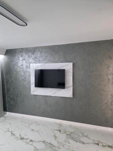 a flat screen tv on a gray wall at Sky deluxe apartment in Giurgiu +6 photos