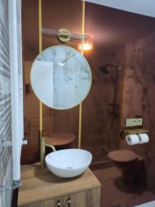 a bathroom with a sink and a large mirror at Sky deluxe apartment in Giurgiu
