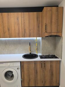 a kitchen with a sink and a washing machine at Sky deluxe apartment in Giurgiu