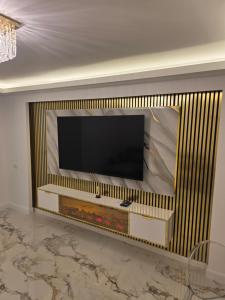 a flat screen tv on a wall in a living room at Sky deluxe apartment in Giurgiu