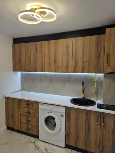a kitchen with a washing machine and a sink at Sky deluxe apartment in Giurgiu