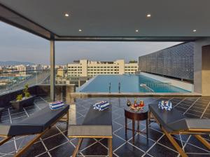 a rooftop patio with a swimming pool on a building at Regenta Devarayah Tirupati in Tirupati