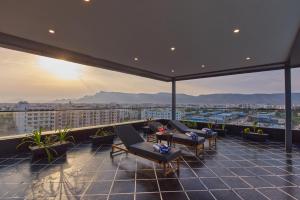 a balcony with chairs and a view of a city at Regenta Devarayah Tirupati in Tirupati