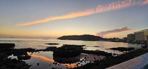 a sunset over a body of water with buildings at Pyeonanhan Guesthouse in Hamdŏng-ni +4 photos