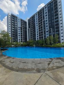 a large blue pool in front of tall buildings at Maru Maya Bay Guest House in Banting