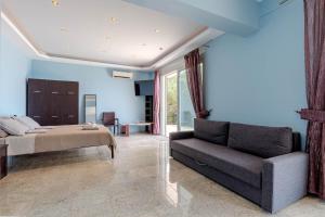a bedroom with a bed and a couch at Daniella with Seaview Pool in Nisaki