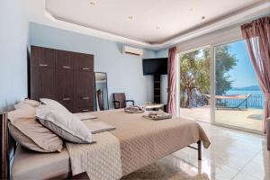 a bedroom with a large bed and a large window at Daniella with Seaview Pool in Nisaki +17 photos