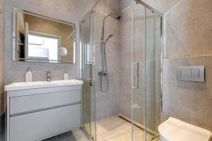 a bathroom with a shower and a sink and a toilet at Daniella with Seaview Pool in Nisaki