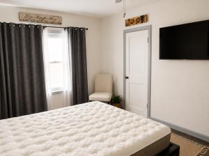 a bedroom with a bed and a flat screen tv at The sunflower stay in Garden City