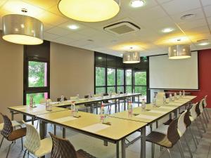 ein Konferenzraum mit langen Tischen und Stühlen in der Unterkunft ibis Styles Castres in Castres