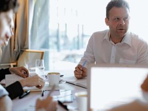 a man sitting at a table in a meeting at Ibis Toulouse Purpan Aeroport in Toulouse