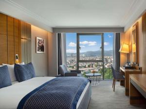 a hotel room with a bed and a large window at Mövenpick Hotel & Thermal Spa Bursa in Bursa