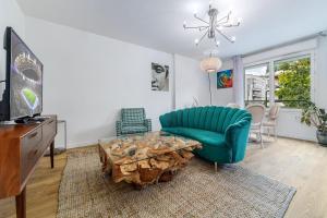 a living room with a green couch and a table at Escapade du Stade BY UTA HOUSE in Saint-Denis