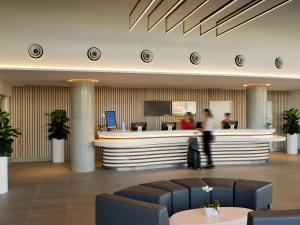 a lobby with a waiting area with people at a counter at ibis Brisbane Airport in Brisbane