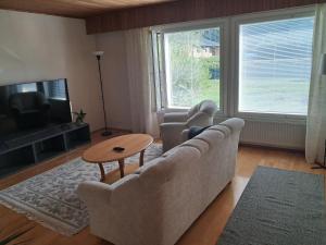 a living room with a couch and two chairs and a table at Jänispolku in Rauma
