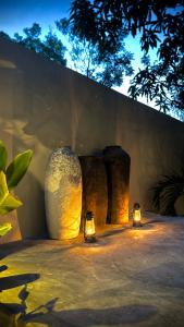 a group of vases with lights next to a wall at Richards Cabanas in Tissamaharama