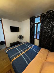 a bedroom with a bed and a flat screen tv at Monoambiente 101 in Trujillo