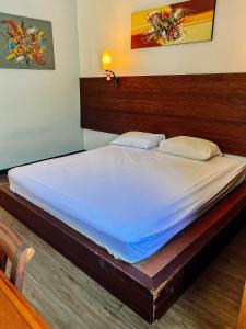 a large bed in a bedroom with a wooden headboard at Vu Exclusive Boarding House in Kerobokan +7 photos