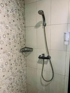 a shower with a shower head in a bathroom at Vu Exclusive Boarding House in Kerobokan