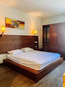 a bedroom with a large bed with white sheets at Vu Exclusive Boarding House in Kerobokan
