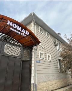 a building with a noaa sign above a garage at Nomad Guest House Osh in Osh +7 photos