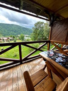 a wooden porch with a bench and a view of a field at Готель in Yaremche