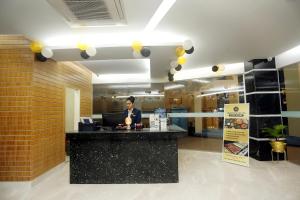 a woman standing at a counter in a office at Grand Mostafa Hotel in Sylhet