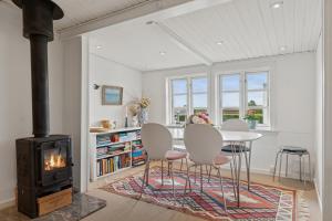 a living room with a table and chairs and a stove at Classic Danish Holiday Home in Karrebæksminde