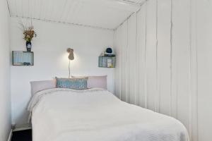 a bedroom with a bed in a white room at Classic Danish Holiday Home in Karrebæksminde