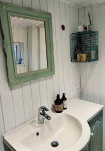 a bathroom with a white sink and a mirror at Classic Danish Holiday Home in Karrebæksminde +29 photos