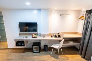 a room with a desk and a tv on a wall at Kuadro Hotel & Suites in Moalboal