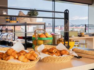 two baskets of croissants and bread on a counter at ibis Styles Geneve Palexpo Aeroport in Geneva