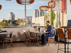 a man sitting at a table in a restaurant at Novotel Sorocaba in Sorocaba +158 photos