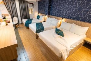 a hotel room with two beds in a room at Kuadro Hotel & Suites in Moalboal +33 photos