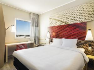 a hotel room with a large bed and a window at ibis Calama in Calama