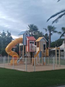 a playground with a slide in a park at Camping Carabasse Vias plage. in Vias