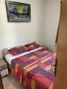 a bedroom with a bed and a painting on the wall at Eko Haus Tesla in Srnava