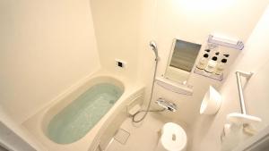 a bathroom with a tub in the corner of a toilet at West Press Sasebo in Sasebo +56 photos