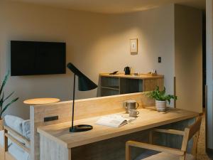 a desk with a television and a lamp on it at HOTEL & KOTEI SOKA in Kyotango