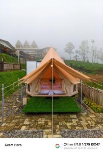 a tent is set up in a field at Telaga Menjer Glamping 2 in Kejajar