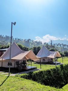 a group of tents sitting in a field at Telaga Menjer Glamping 2 in Kejajar