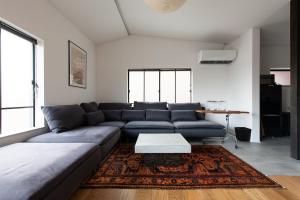 a living room with a blue couch and a table at Kamin Kanazawa in Kanazawa