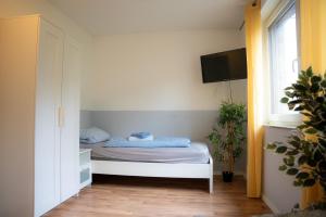 a bedroom with a bed with a tv on the wall at OMNI - Homes - Waldstraße in Falkensee
