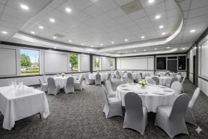 a conference room with white tables and chairs at Super 8 by Wyndham Harrison OH in Harrison