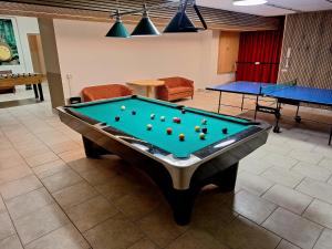 a pool table in a room with ping pong balls on it at Hotel Pörnbacher in Valdaora