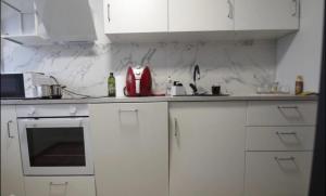 a white kitchen with white cabinets and a sink at ST Luxury Apartment Riga in Riga +4 photos