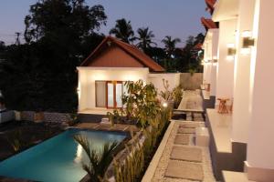 a house with a swimming pool in front of a house at The Tamarin Villas in Nusa Penida