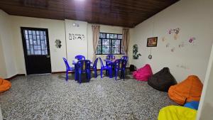 a room with blue chairs and a table with bags at El Cacique Villeta Hostal in Villeta
