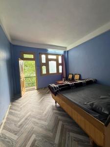 a bedroom with a large bed in a blue wall at The Soul Himalaya in Tosh