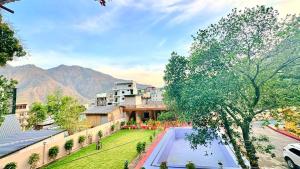 an overhead view of a building with a swimming pool and mountains at Boho Stays Rishikesh in Rishīkesh +21 photos